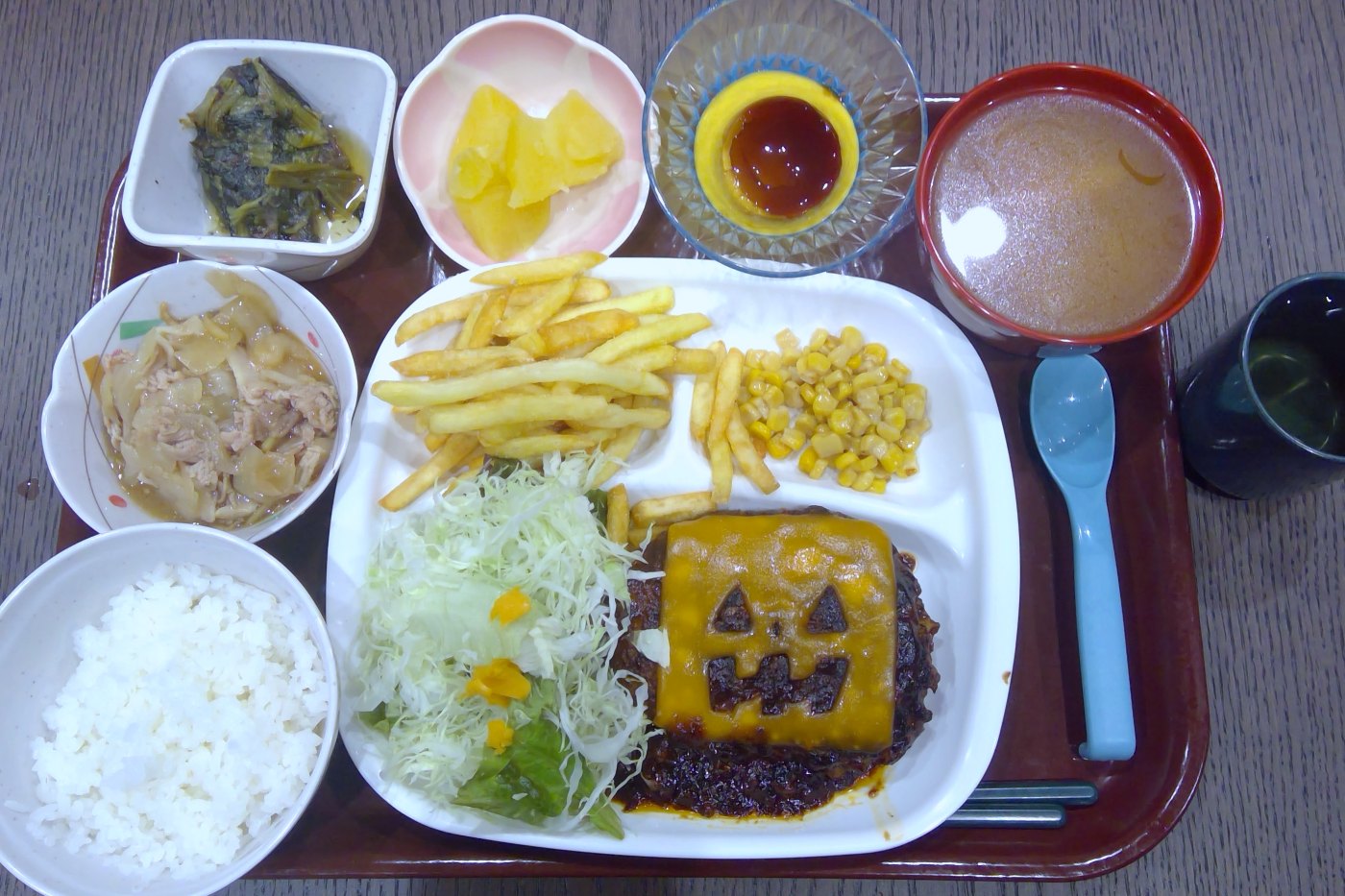 ハロウィーンの夕食。かぼちゃのおばけの顔をつけたチーズハンバーグ、ポテト、コーン、サラダ